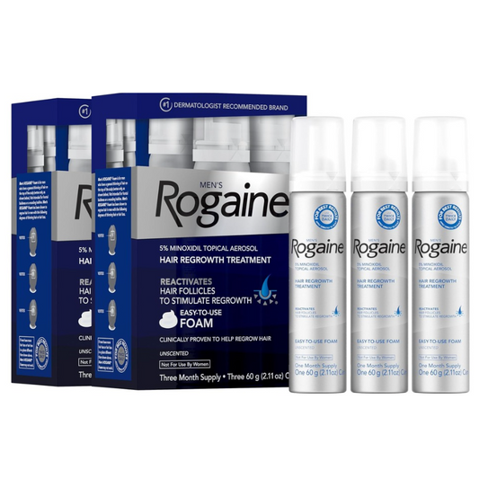 Rogaine hair regrowth treatment shown with a blue and white product box and three silver spray bottles on a plain white background.